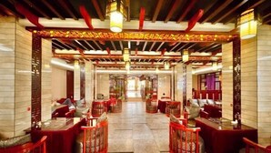 A corridor with red seating areas and a patterned ceiling. - Yongshun Minzu Hotel (Yongshun)