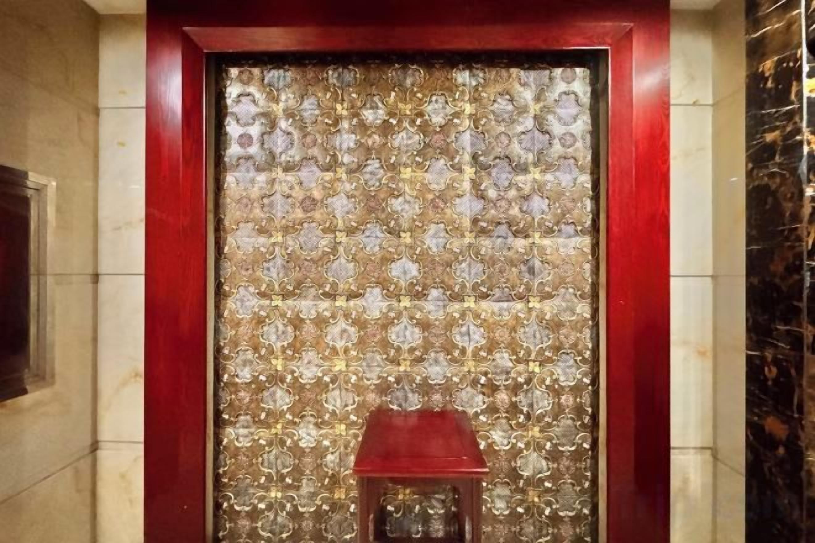 A door with a patterned design and a small stool in front.