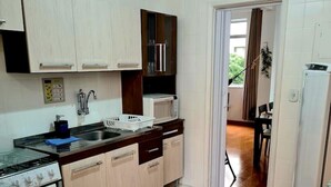 A compact kitchen with a stove, microwave, and cabinets.