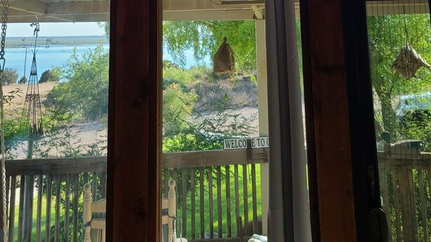 Una habitación con un amplio ventanal que da a una vista panorámica, vigas de madera y una decoración rústica.