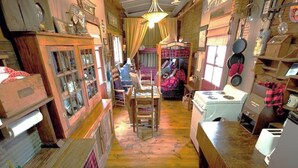 Une petite cuisine rustique, avec des meubles en bois, un poêle et un coin repas comprenant une chaise et une table.