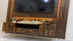 Uma unidade de entretenimento de madeira com uma TV de tela plana montada acima.