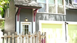 A two-story house with a front porch, a garage, and a wooden fence.