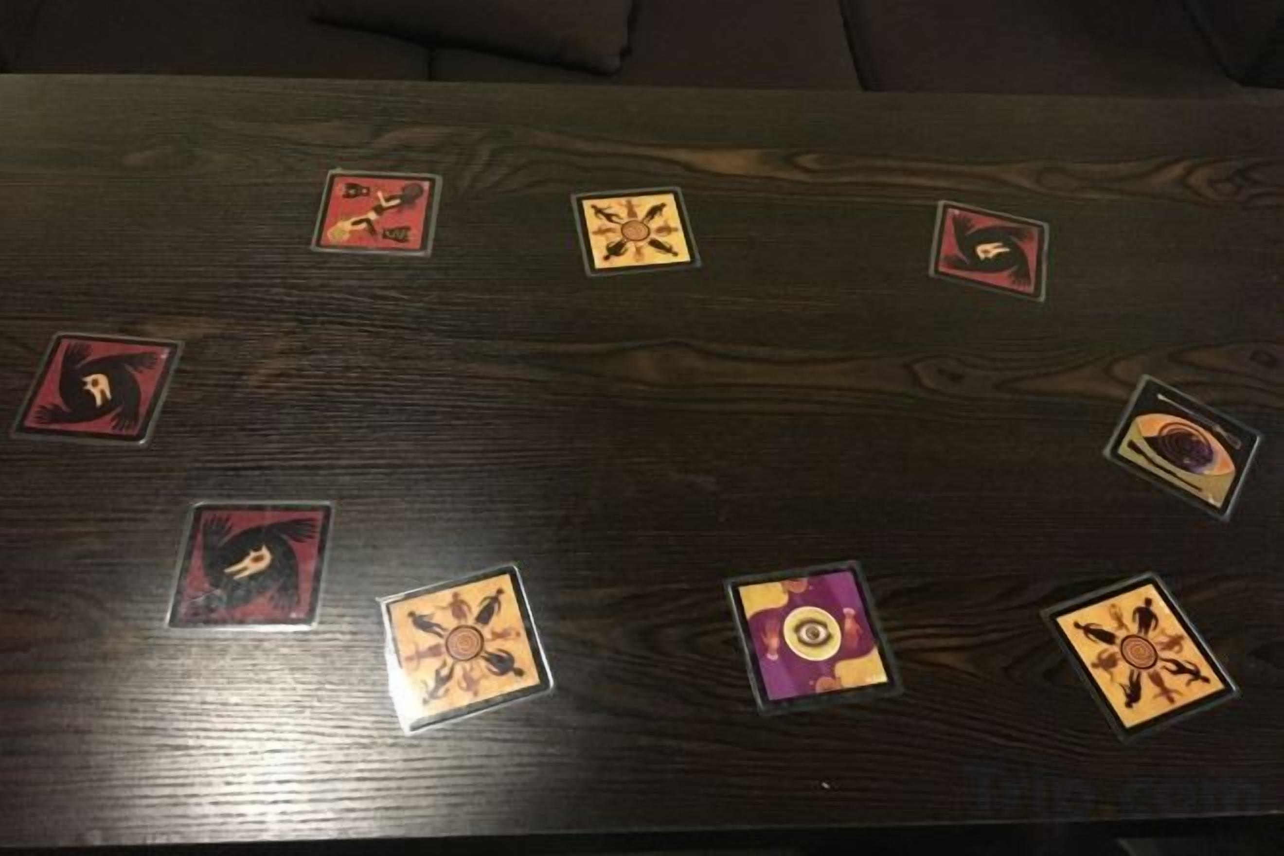 Une table en bois sur laquelle sont disposés en cercle six pions de jeu.