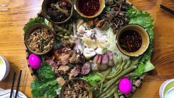 A table with various food items and condiments, including meat, vegetables, and sauces.