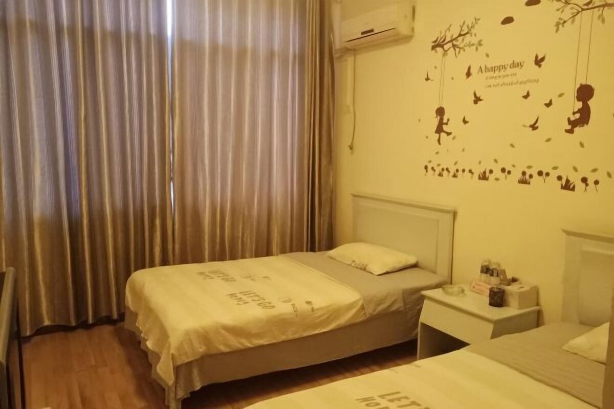 Quarto com uma cama de solteiro, mesa de cabeceira e decoração na parede.