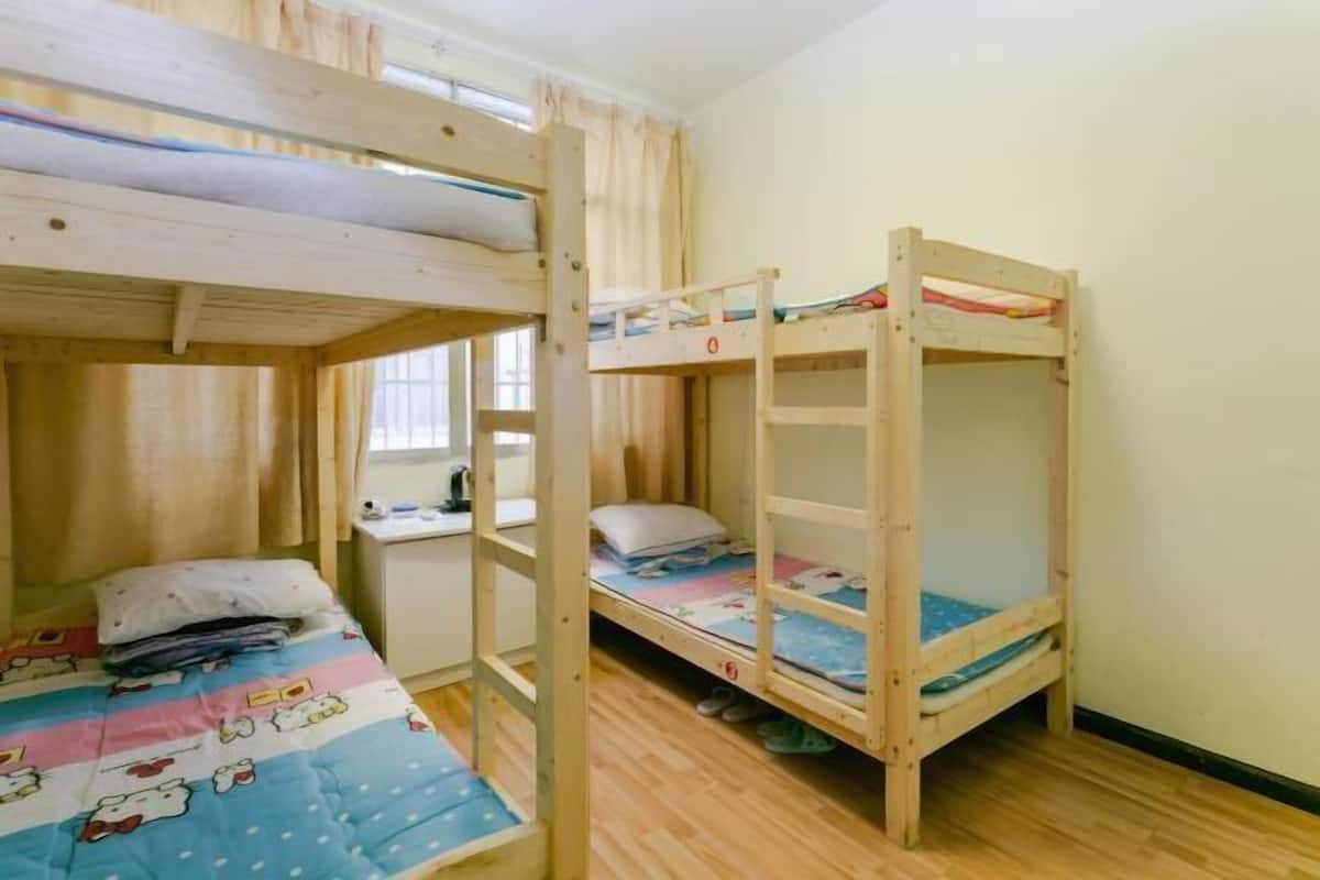 Una habitación con literas, un escritorio y una ventana.