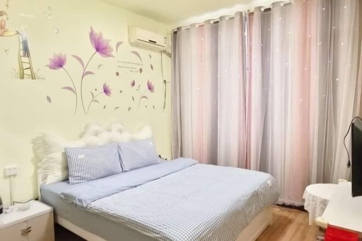 Un dormitorio con cama, mesita de noche, escritorio y silla.