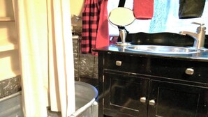 A bathroom with a black vanity, a sink, and a mirror.