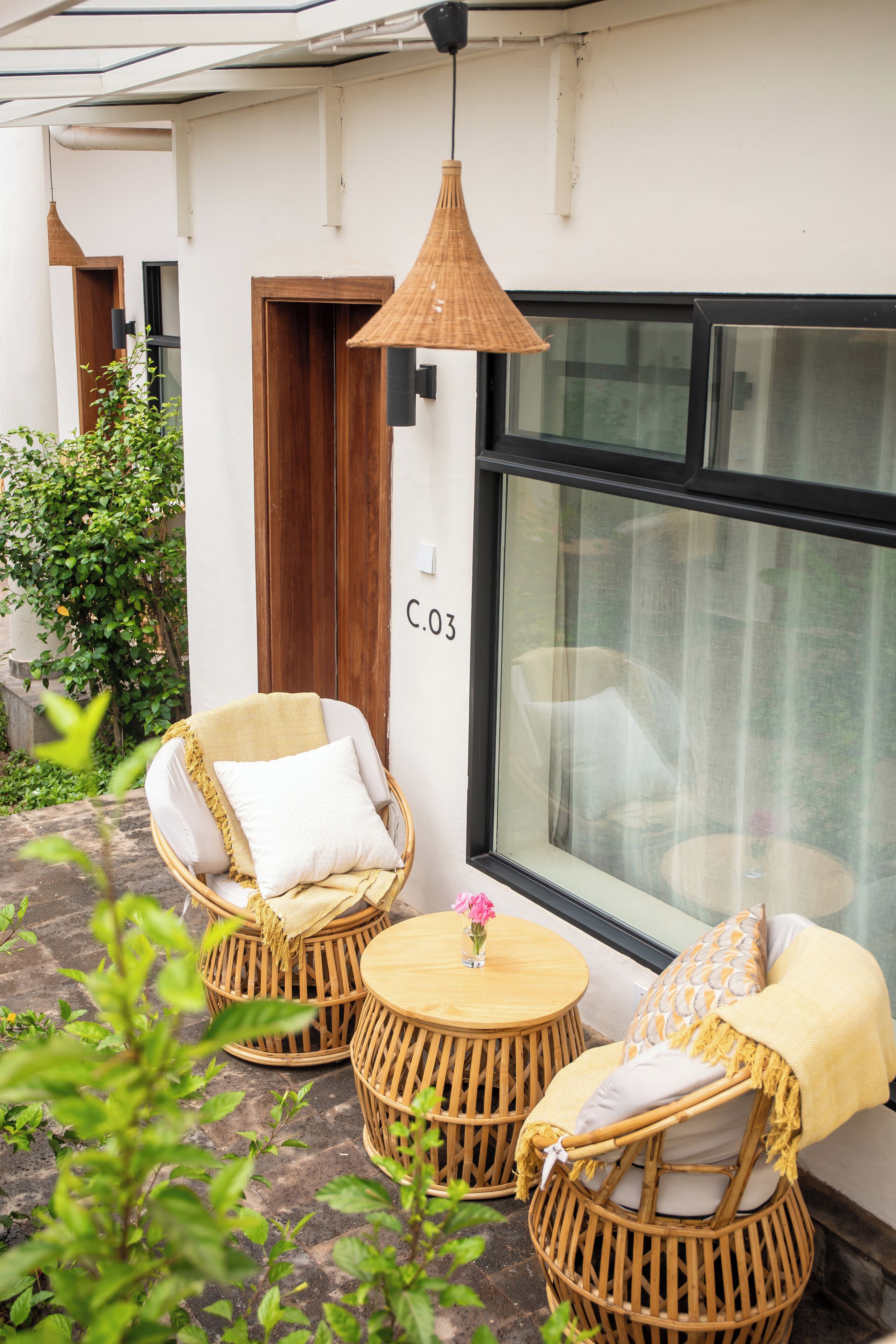 Wicker furniture, a window with a number, and a plant.