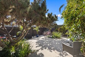 A patio area with a wicker chair, potted plants, and a bicycle. - Venice Haven (Venice)