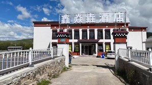 A hotel with a traditional architectural style, featuring a prominent entrance and a clear sky in the background.