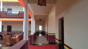 A hotel lobby with a central staircase, seating areas, and a red carpet.
