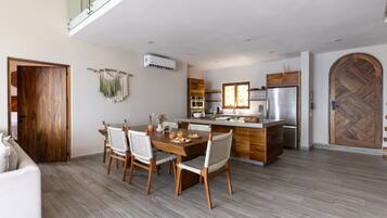 Una cocina moderna con horno empotrado, refrigerador y puerta de madera.