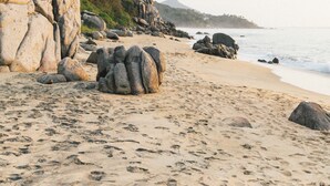 A beach with large rocks, a sandy shore, and a mountain in the background. - La Joya Sayulita (Sayulita)
