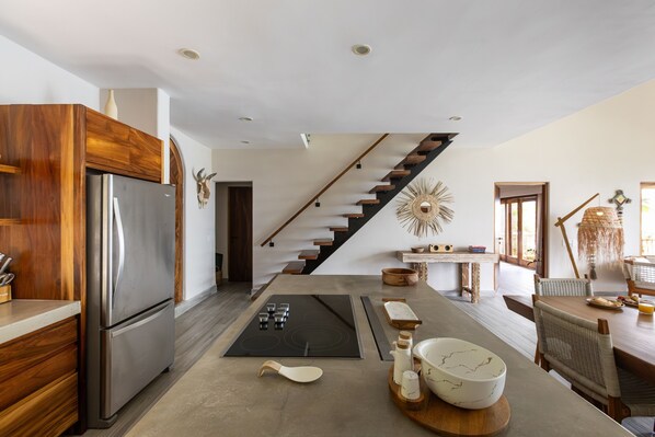 A modern kitchen with a built-in stove, wooden cabinets, and a stainless steel refrigerator. - La Joya Sayulita (Sayulita)