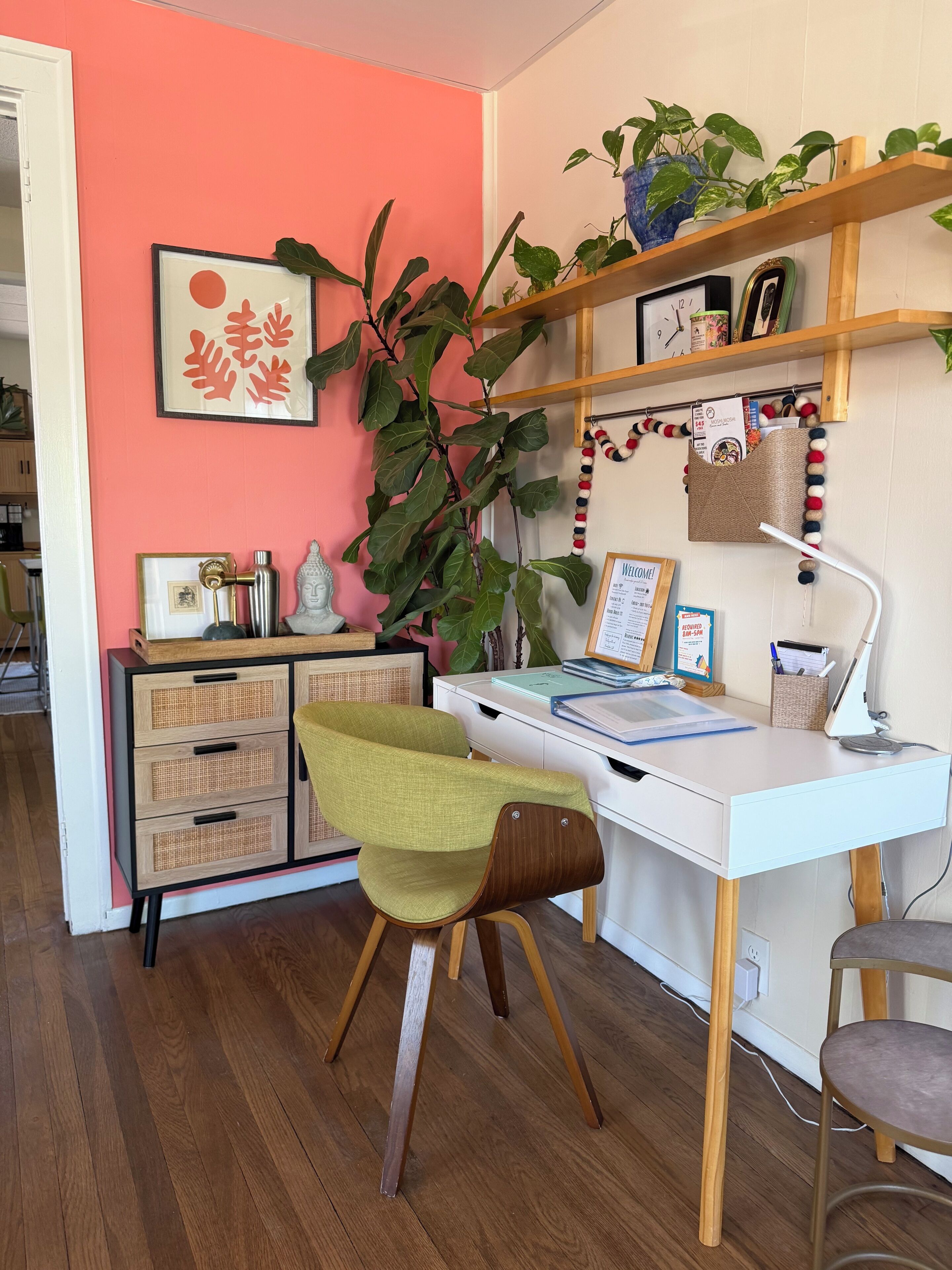 A workspace with a desk, chair, and shelving unit.