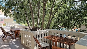 An outdoor patio with wooden furniture and a white balustrade. - NEW Holliday Apartment A2+2, Family house, garden pool, terase, wi-fi (Radonic)