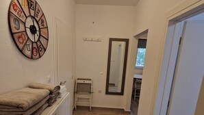 A hallway with a clock, a mirror, and a stack of towels on a cabinet. - NEW Holliday Apartment A2+2, Family house, garden pool, terase, wi-fi (Radonic)