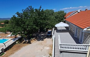 Ein Wohnhaus mit Swimmingpool, überdachter Terrasse und Blick auf die umliegende Landschaft.