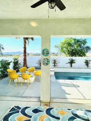 A pool area with yellow chairs, a pool, and a view of mountains. - 4 Bed Family Villa - pool/spa/bbq/fire pit (Indio)