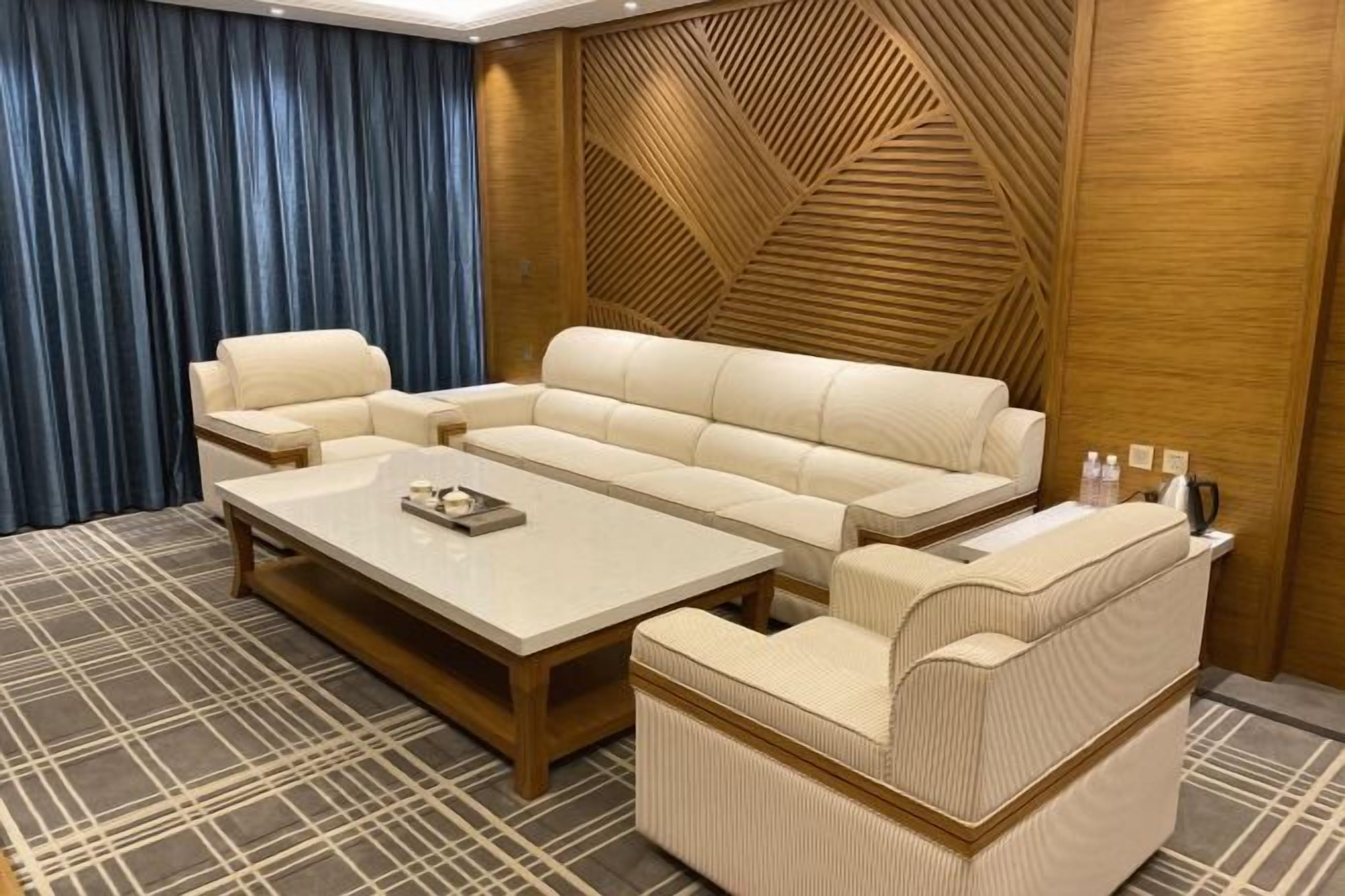 A modern living room with a sectional sofa, a coffee table, and a patterned rug.
