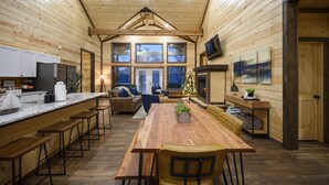 Une cuisine spacieuse avec un décor intérieur en bois, une grande table à manger et des tabourets de bar.