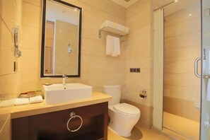 Een moderne badkamer met een wastafel, toilet en douchecabine van glas.