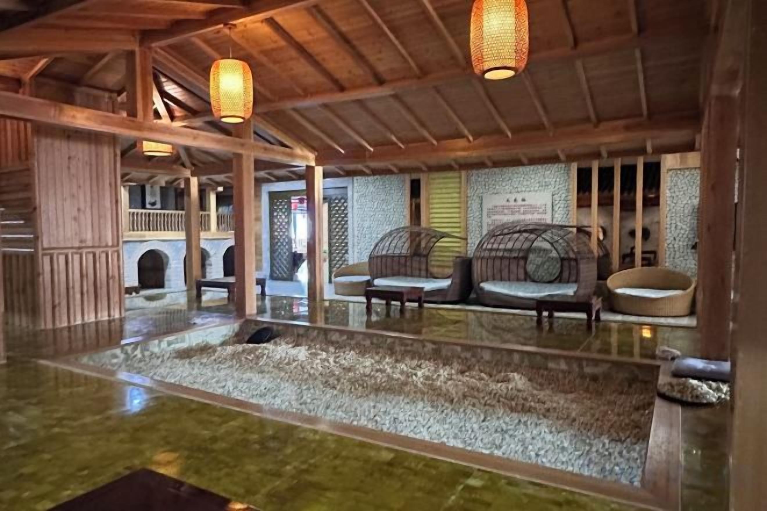 A traditional Japanese-style interior with tatami flooring, low wooden beams, and a seating area with cushions.
