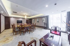 A dining area with a round table, chairs, and a chandelier. - Xiyue wanda Hotel (Xiuyan)