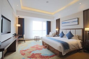 A hotel room with a bed, a desk, a TV, and a large window. - Xiyue wanda Hotel (Xiuyan)
