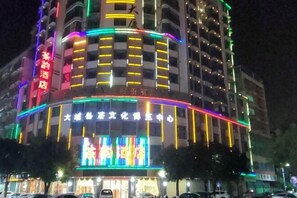 A multi-story hotel with illuminated signage and a prominent entrance. - Chayun Hotel (Dabu)