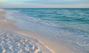Una playa con orilla arenosa y olas suaves.