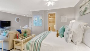 A modern bedroom with a large bed, a television, and a desk.