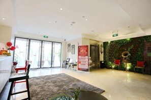 A hotel lobby with a reception desk, seating area, and a green wall with plants. - Sotel Inn (Wenzhou Xincheng Convention and Exhibition Center) (Wenzhou)