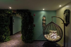 A room with a hanging chair, a wall decorated with circular plates, and a green wall with a leafy archway. - Sotel Inn (Wenzhou Xincheng Convention and Exhibition Center) (Wenzhou)