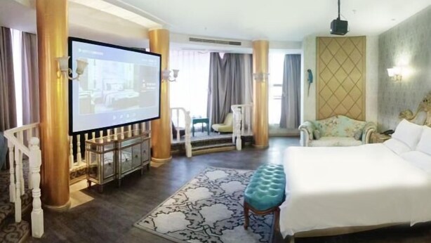 A hotel room with a large bed, a television, a seating area with a chair, and a decorative wall. - Sotel Inn (Wenzhou Xincheng Convention and Exhibition Center) (Wenzhou)