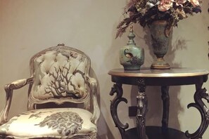 A vintage chair with a floral pattern and a table with a vase. - Sotel Inn (Wenzhou Xincheng Convention and Exhibition Center) (Wenzhou)