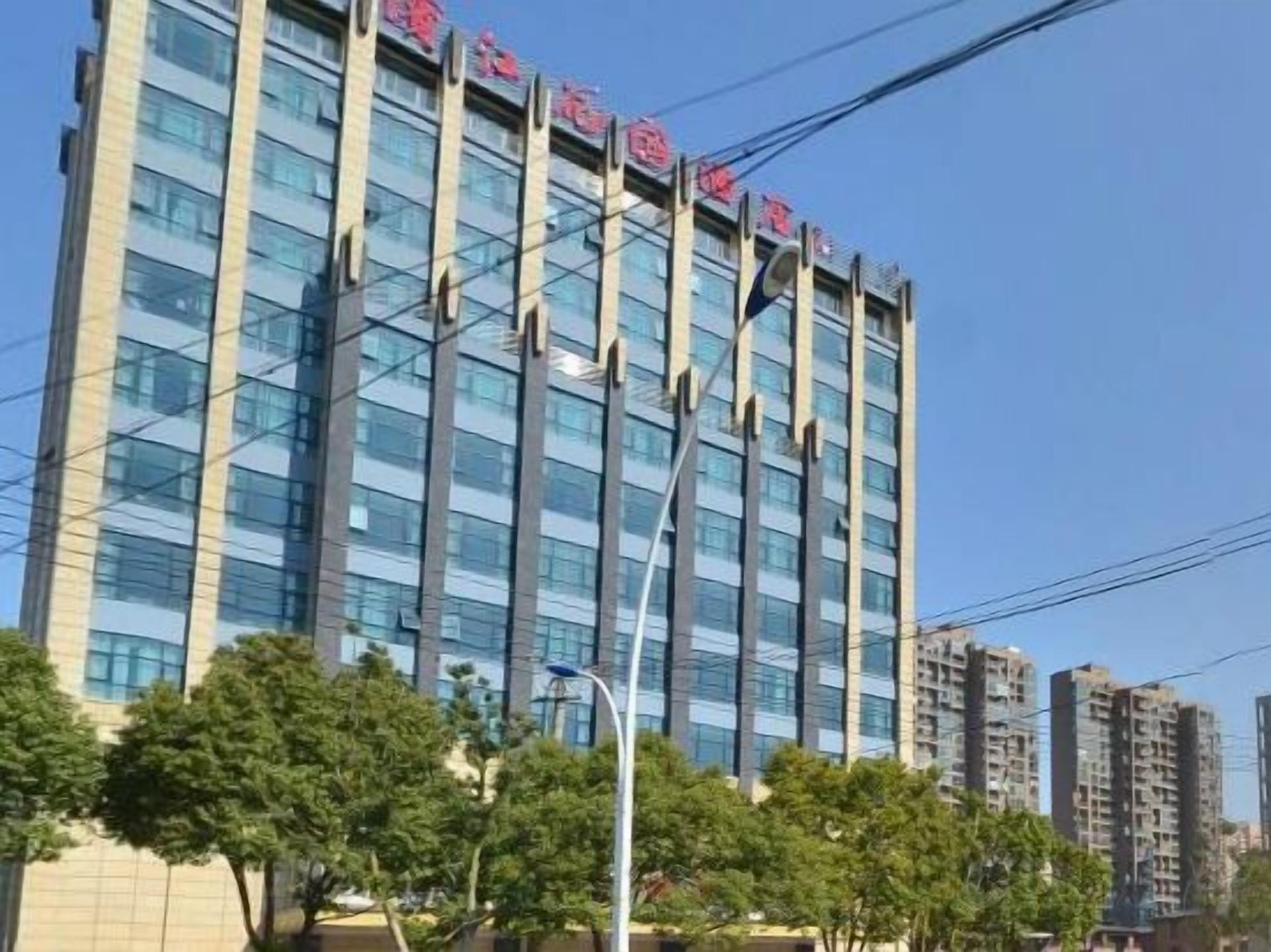 Un edificio a più piani dal design architettonico moderno, caratterizzato da linee verticali e una facciata in vetro trasparente.