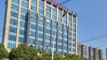 Un edificio a più piani dal design architettonico moderno, caratterizzato da linee verticali e una facciata in vetro trasparente.