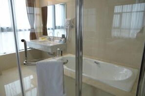 A modern bathroom with a glass-enclosed shower, a white bathtub, and a vanity with a mirror and sink. - Riverside Garden Hotel (Taicang)