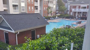 Un edificio residencial con piscina, rodeado de exuberante vegetación.