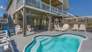 A two-story building with a pool area featuring lounge chairs and a hot tub. - A Beach Haven - Oceanfront Home w/Private Pool and Offers Early Check-In/Late Check-Out! (Holden Beach)