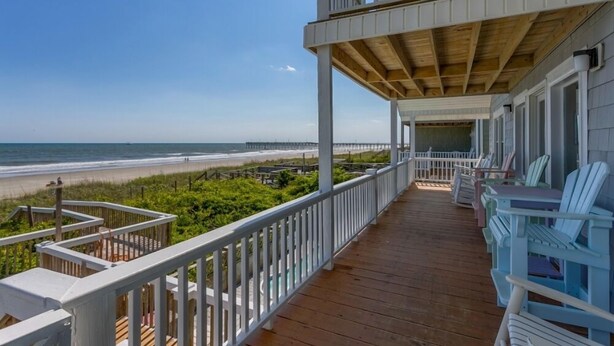 A wooden deck with white railings overlooking a beach. - A Beach Haven - Oceanfront Home w/Private Pool and Offers Early Check-In/Late Check-Out! (Holden Beach)