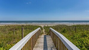 A wooden boardwalk leading to a beach with a clear sky. - A Beach Haven - Oceanfront Home w/Private Pool and Offers Early Check-In/Late Check-Out! (Holden Beach)
