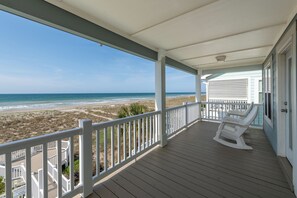 A covered porch with a view of the beach and ocean. - Hobbs Realty - Oceanfront Home w/Private Pool And Offers Early Check-In! (Holden Beach)