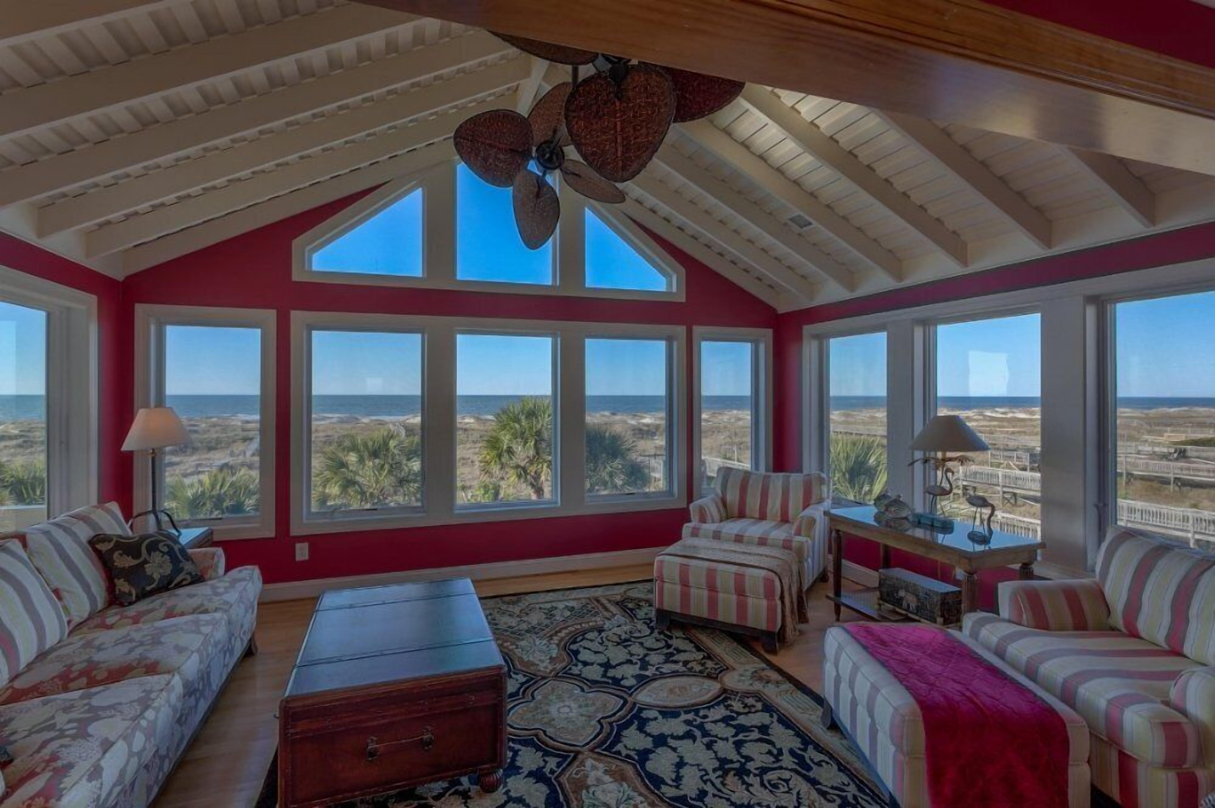 A spacious room with large windows, a ceiling fan, and a view of the landscape.
