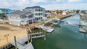 A waterfront property with a two-story house, dock, and marina.