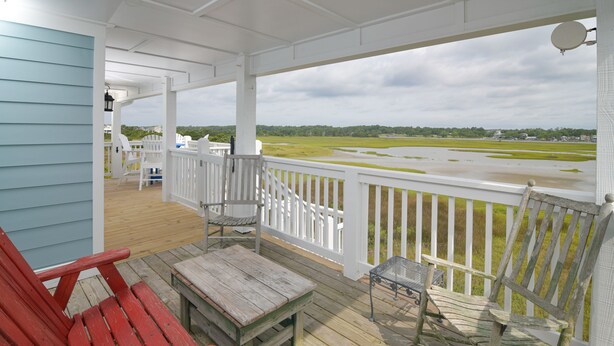 A covered porch with a view of a marshy landscape.