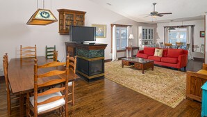 A dining area with a wooden table and chairs, a television, and a cabinet.